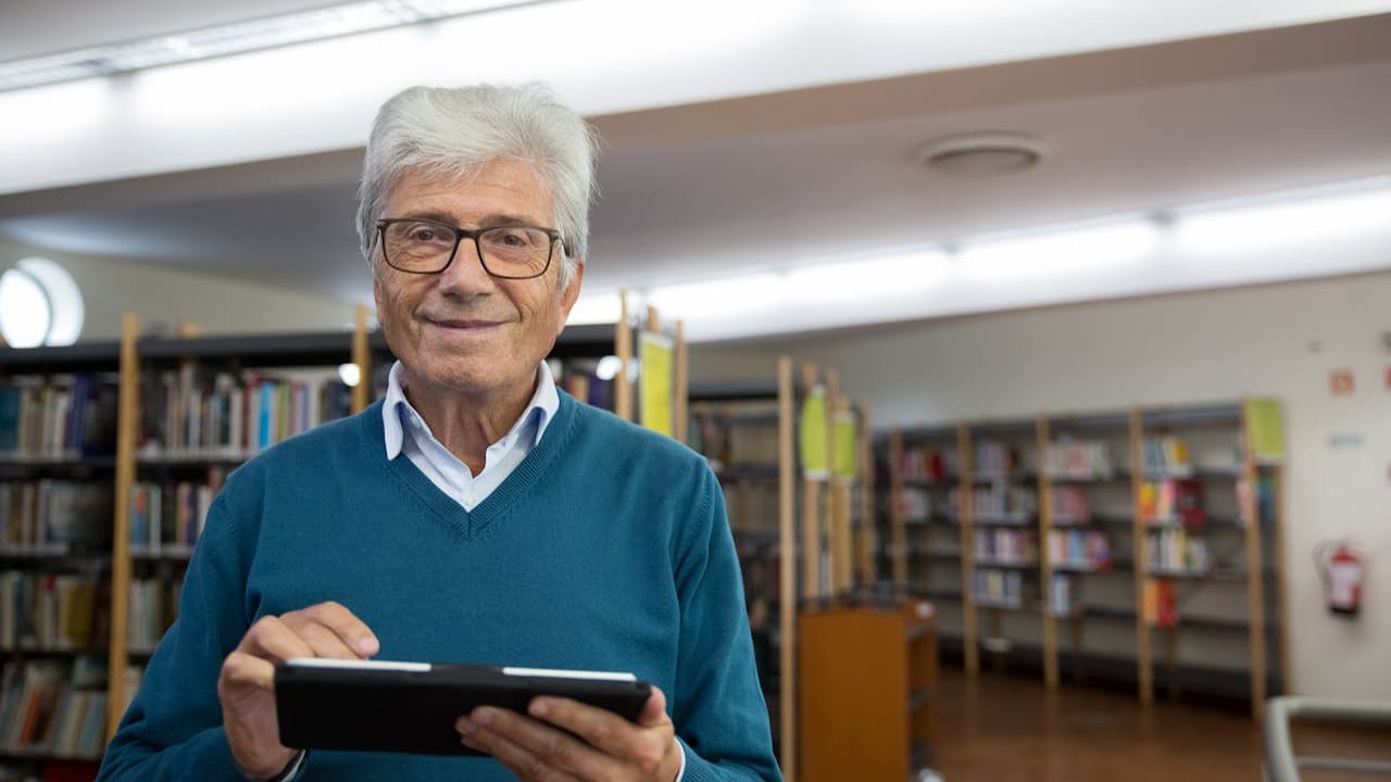 Homem lendo e-book em tablet na biblioteca